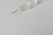 Close up view of a syringe and a needle with a drop on white background. Flu shot or drug abuse concept.