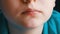Close up view of teenager`s mouth. A boy with an appetite eats a fried chicken wing in a fast food restaurant