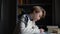 Close-up view of thoughtful smart schoolboy making notes writing essay in notebook sitting at desk.