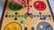 Close up view on Throwing a die on the game board. Playing Ludo or Pachisi board game on beautiful wooden play board