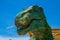 Close Up view to an opened-mouth head of dinosaur. On a blue sky background