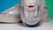 close up view on toe cap suede crema sneaker shiny gray inserts rotating on isolated green and blue background