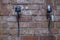Close up view of two black iron candle holders on brick wall background.