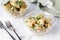 Close up view of two bowls of creamy potato and bean salad ready for eating.