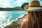 Close up view of an unrecognizable brunette girl from behind, wearing a straw hat in the summer of 2021. Distant look to the