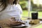 Close up view of unrecognizable woman grabbing a toast slice with strawberry jam and garden in the blurred background