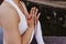 close up view of unrecognizable young asian woman doing yoga in a park. Sitting on the bridge with praying hands position and