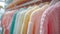 Close-up view of a variety of colorful youth cashmere sweaters and hoodies on a clothes rack, highlighting the detailed