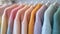 Close-up view of a variety of colorful youth cashmere sweaters and hoodies on a clothes rack, highlighting the detailed