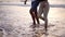 Close up view video of man and woman walking barefeet at sandy beach by ocean. Happy couple enjoying summer vacations at