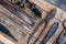 Close up view vintage rusted tools on old wooden table: pliers, pipe wrench, screwdriver, hammer, metal shears, saws and other.