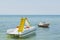 Close up view of water slide catamaran and rubber boat on sea coast on beautiful nature background.