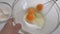 Close up view of whipping fresh eggs in a bowl with electric whisk