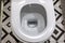 Close up view of white ceramic toilet in modern bathroom. Open toilet bowl