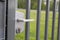 A close-up view of the white handle on the steel fence gate.