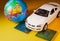 Close up view of a white toy car on top of a microprocessor and a world globe.