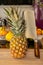 Close-up view of a whole fresh whole pineapple fruit with a cleaver on a cutting board