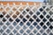 Close-up view of a wire fence with frost with ice crystals under a blue sky with a blurred background