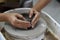 Close up view of woman creating handicraft crockery on the pottery wheel in workshop