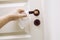 Close up view of woman hand using antibacterial wet wipe for disinfecting home room door link.