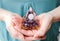 Close up view of woman hands holding and using Orgonite or Orgone pyramid at home while meditating.