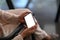 Close up view of woman using mock up smart phone with white screen while sitting in her workspace.