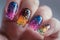 A close-up view of a womans hand showcasing a vibrant and colorful nail polish design, adding a touch of elegance and