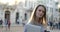 Close-up view of a young attracive business lady holding a hotebook and coffee in her hands and looking in the camera.