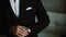 Close-up view of young businessman puts on the black tuxedo. Man preparing to important event. Successful male at home.