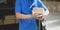 Close-up view of young delivery man checking the products to customer while standing right next to his car