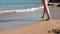 Close up view of young female legs on sandy shore. Close up view of female beautiful legs on sea. Close up of female legs walks on