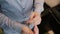 Close-up view of young male hands getting dressed at morning. Man buttons cuffs on a shirt, preparing for work.