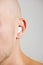 Close up view of a young man with sterile cotton wool in his ear.