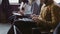 Close-up view of young multiracial team sit at business meeting. Man and woman make the notes on tablet and notebook.