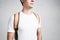 Close-up view of young stylish man wearing blank white t-shirt and backpack. Studio portrait