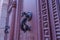 Close up of vintage aged door handle on a red wooden door