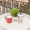 Close-up of vintage coffee mug with coffee maker on white table on balcony outdoors