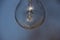Close up of a vintage lightbulb hanging outdoors with condensation droplets inside