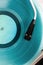 Close up of vintage turntable record player with turquoise vinyl