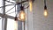 Close-up of vintage yellow lamps of different shapes in a light room against a brick wall and window. Media. Decorative