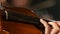 Close up of a violin girl fingering the strings. Black smoke background