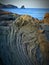 Close up of a volcanic rock with the background of the sea magma