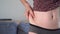 Close up of waist side of girl`s abdomen. Excess weight concept