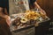 Close-up of a waiter serving delicious barbecued prime rib with french fries