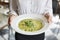 Close Up Of Waitress Holding Plate Of Pea And Mint Risotto In Restaurant