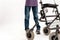 Close up of walker of disabled boy with cerebral palsy taking steps, using it isolated over white background