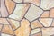 Close-up of a wall tiled with sandstone tiles. Chaotic stone mosaic. Natural stone. A versatile background.