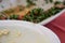 A close-up of a wasp on the edge of a white plate of hummus