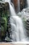 Close up of waterfall cascade over the mossy rock