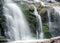 Close up of waterfall cascade over the mossy rock